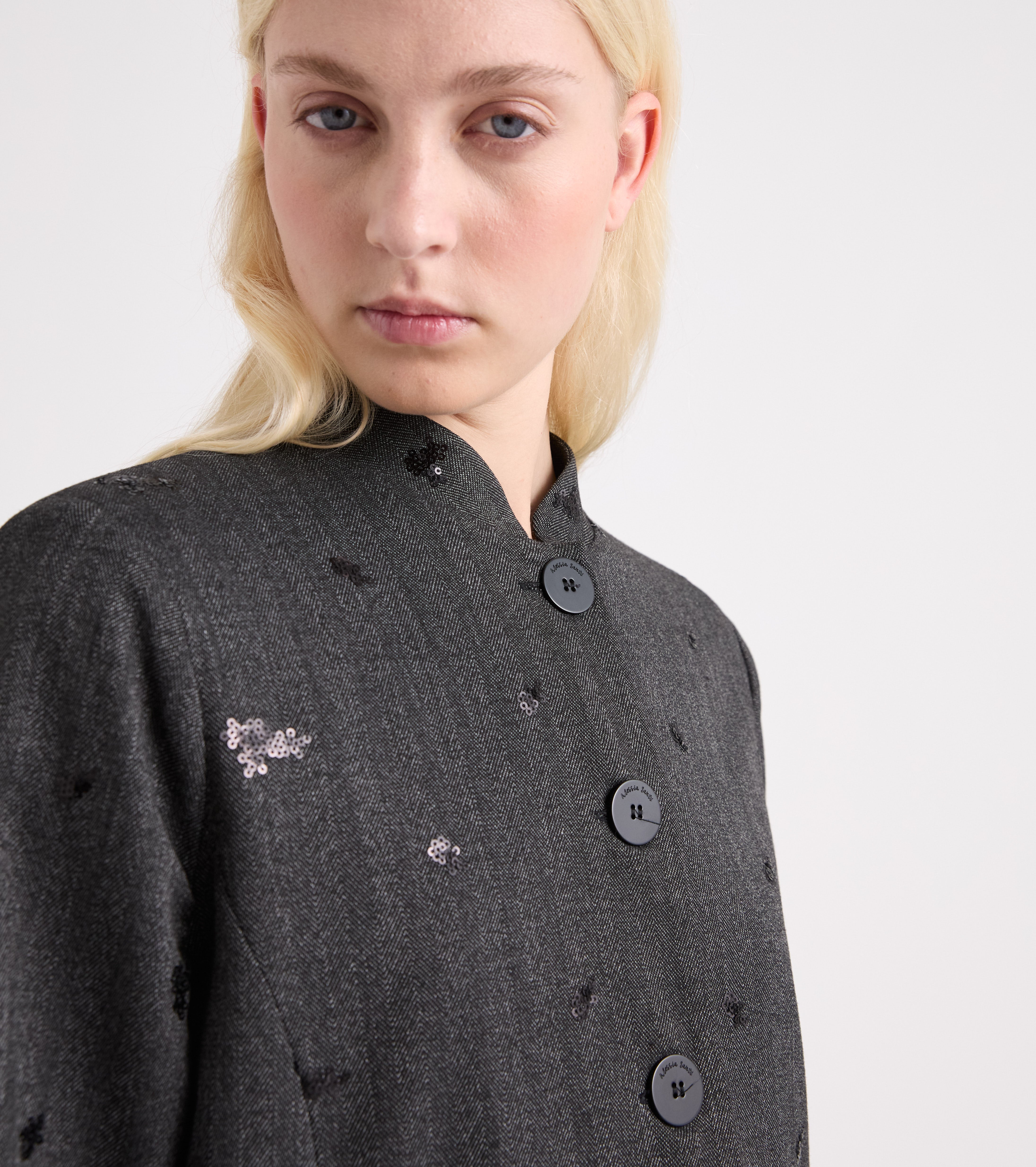 Chaqueta elástica con bordados y botones en tonos sal y pimienta