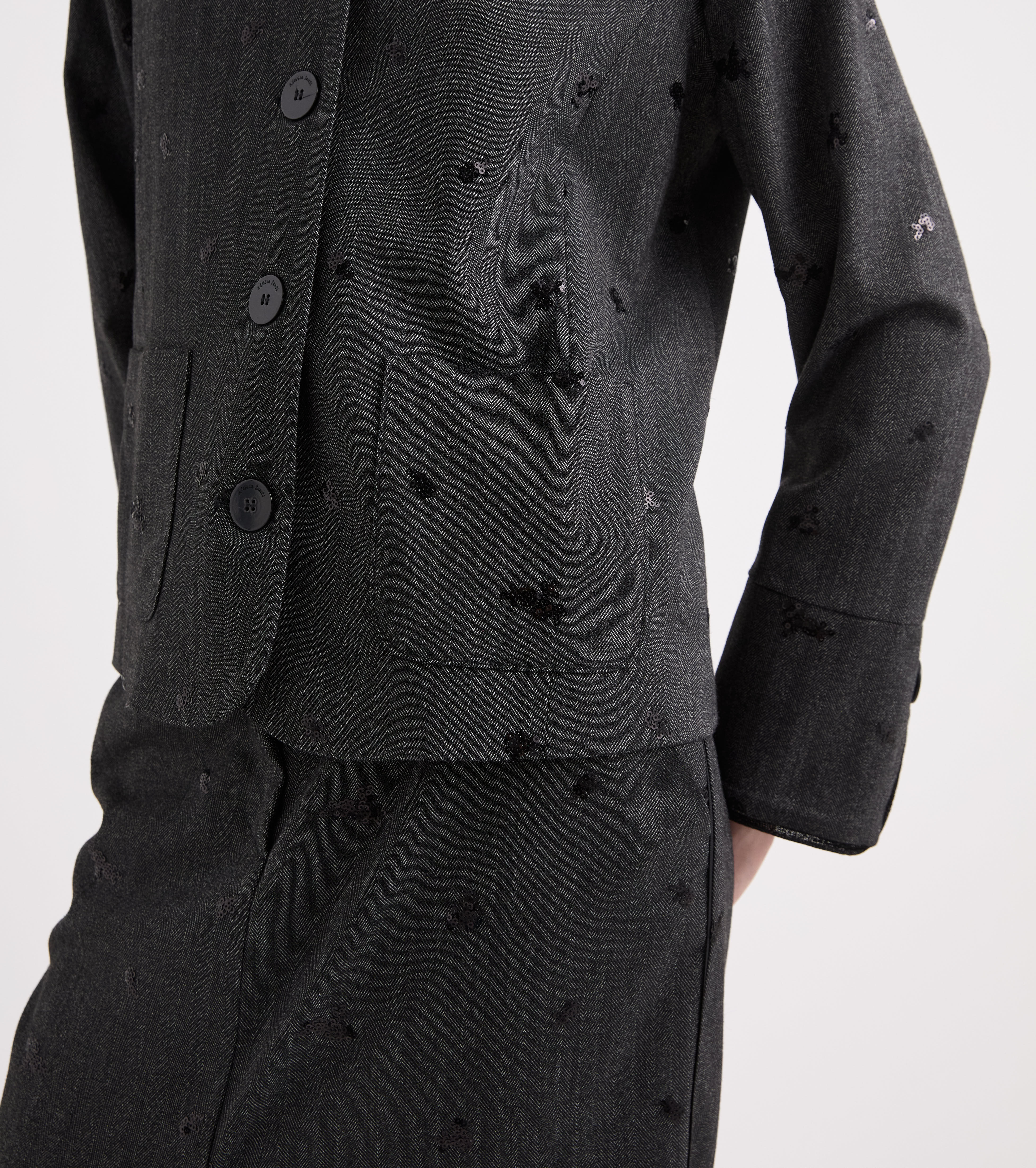 Chaqueta elástica con bordados y botones en tonos sal y pimienta